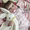 Bebê reborn realista com roupa rosa e pelúcia